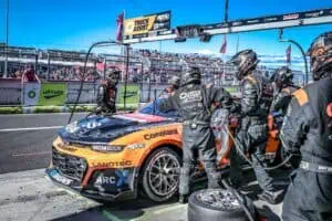 race car in a pitstop with a large crew