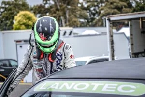 Driver getting into a racing car with Lanotec logo