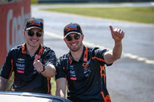 Two men giving a thumbs up and smiling to the camera