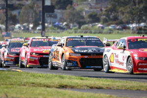 four race cars in a row on a racetrack